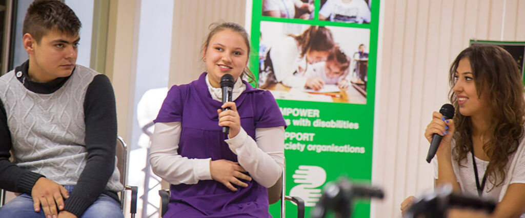 Här ser vi Elena på scen med mikrofon i handen.