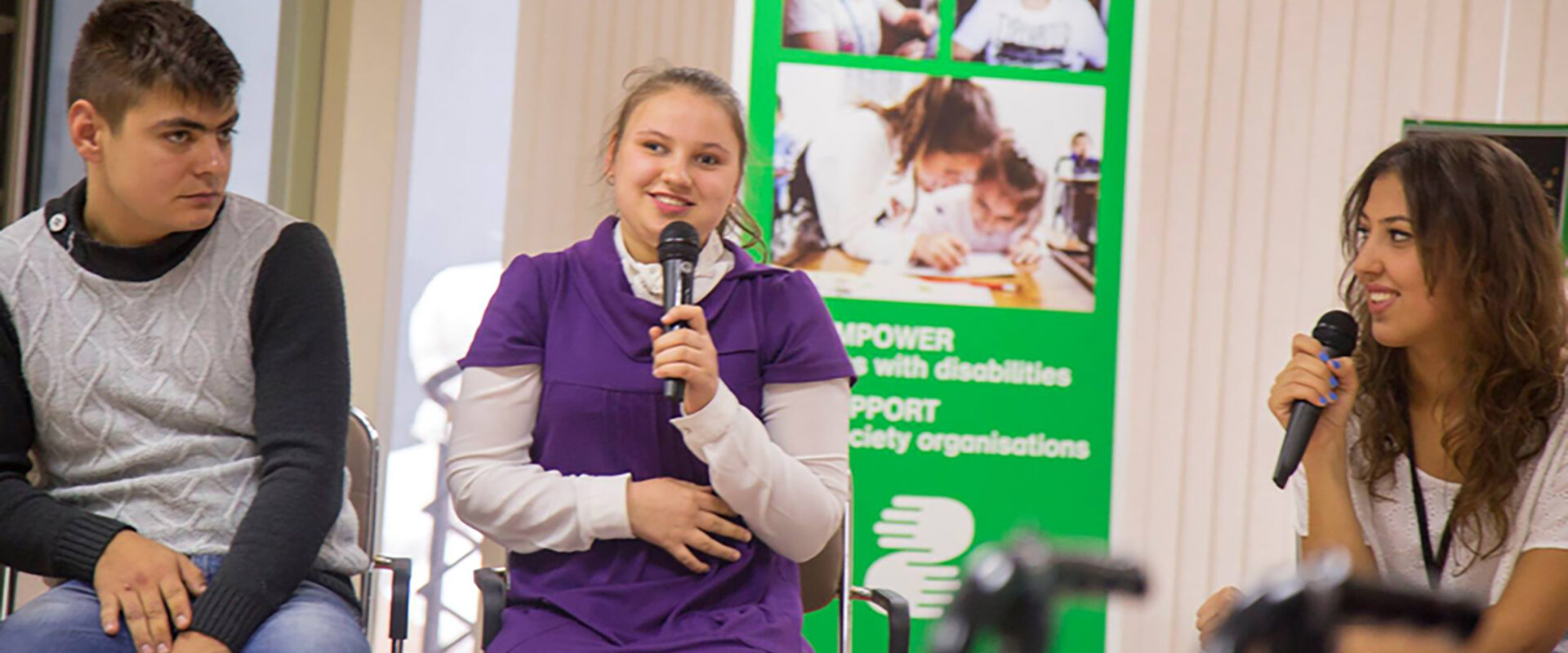 Här ser vi Elena på scen med mikrofon i handen.