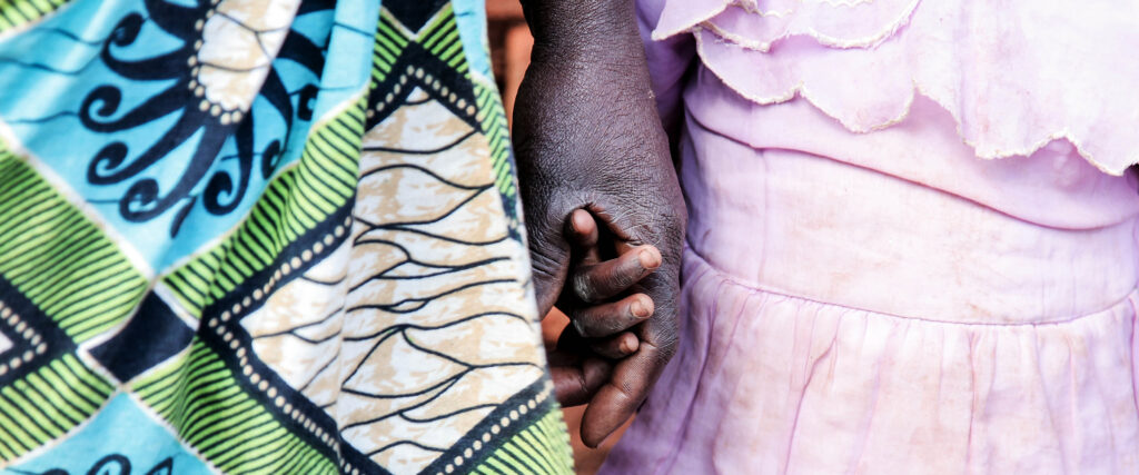 Vuxen håller barns hand