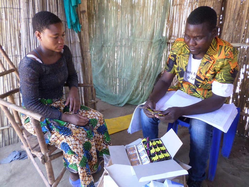 Flicka i Malawi får kondomer av hälsoarbetare