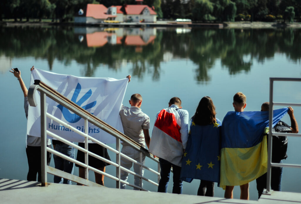 Ungdomar från Stan står med flagga för Mänskliga rättigheter.
