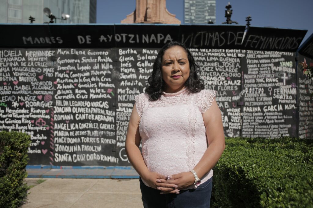 Kvinna som står framför en vägg med spansk text.